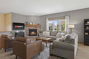 Main level living room with high end furniture, gas fire place, 50" smart TV, and an open living concept.