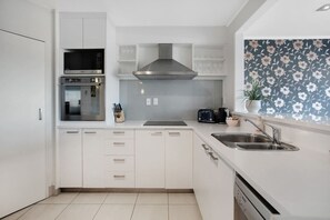 The kitchen has a cook top, oven, microwave, dishwasher and fridge/freezer.