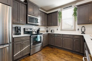 Kitchen with toaster, drip coffee pot, electric stovetop, blender, and more