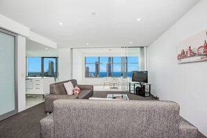 Maximising the view, the cosy lounge area features a flat-screen TV and two sofas.