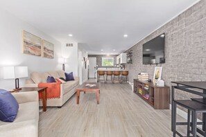 The living room features a large Queen sofa bed, a smaller Twin sofa bed, and a Smart TV for your entertainment.