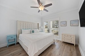 Ground floor King bed with TV, closet, and full bath off hallway.