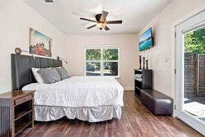 Master bedroom with a King bed, TV, yard access, and en suite