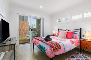Lower bedroom, Queen bed, TV, sliding doors to balcony, built in robes