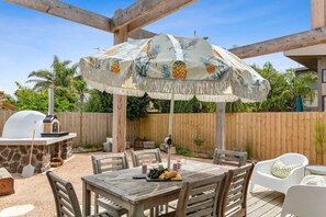 Fully landscaped featuring an outdoor table, fire pit and pizza oven.