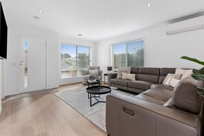 The main lounge features a luxurious leather lounge with electric recliners to relax in, complete with smart tv