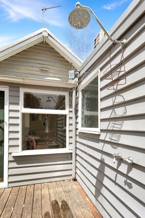 Large fully enclosed yard with outdoor shower, hot and cold.