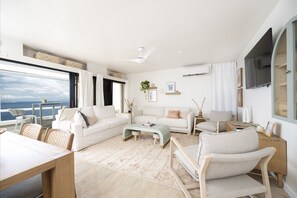 Large sliding doors let the ocean breeze in, seamlessly blending indoor and outdoor living.