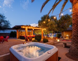 Sparkling pool, hot tub, sun loungers, gazebo, firepit, BBQ, cornhole, and ample seating.