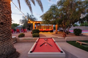 Sparkling pool, hot tub, sun loungers, gazebo, firepit, BBQ, cornhole, and ample seating.
