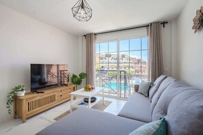 Living Room with TV, Sofa Bed, Dining Table, Coffee Table and Pool View