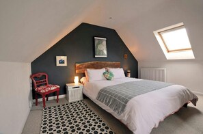 Bedroom with king size bed, bedside tables and lamps, chair