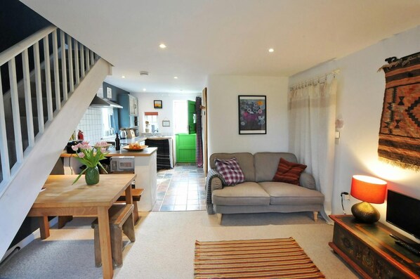 Living area with sofa, dining table, tv, kitchen area