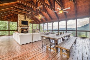 Covered sitting area with fireplace and TV and more amazing mountain views