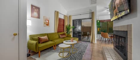 Living room, just off the kitchen, with sleeper sofa, smart TV, and decorative fireplace