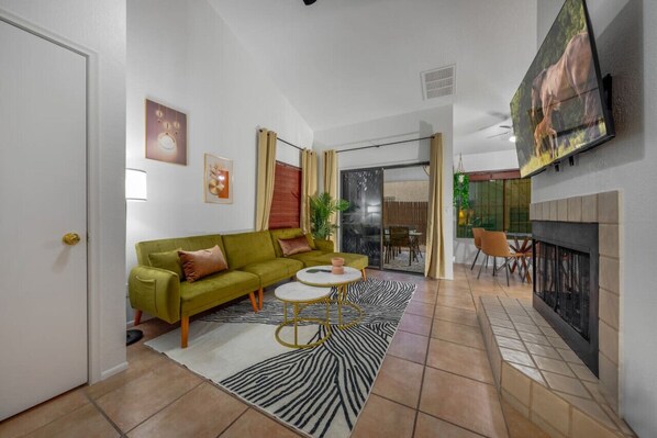 Living room, just off the kitchen, with sleeper sofa, smart TV, and decorative fireplace