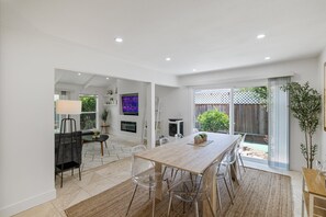 Spacious open-concept dining room featuring a expandable modern dining table set that sit 10 guests