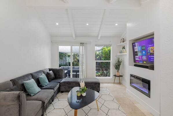 Step into our modern living room with plenty of natural light, featuring a sleek media wall