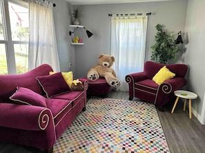 Fun couches and a fuzzy bear await your relaxing company.