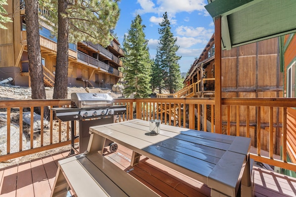 The kitchen opens up to a large deck with more outdoor seating and a BBQ.