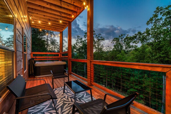 Relax on a private deck with hot tub, string lights, and Mountain views in TN.