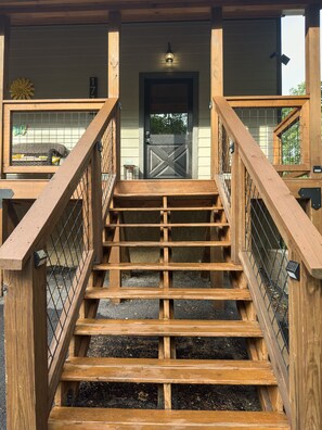 Rustic cabin entrance with porch and railings—your serene mountain escape!