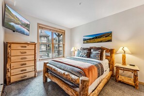 Bedroom 1: King bed, closet, dresser, 69” TV, en suite bath
