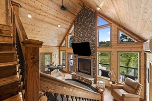 Relax in our spacious and cozy living room, complete with reclining chairs, a large flat-screen TV, and breathtaking views of the South Fork Shenandoah River through expansive windows.