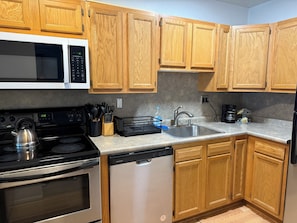 Step into a well-appointed kitchen designed for convenience. It includes a full-sized refrigerator, range, and plenty of counter space for meal prep. You'll find generous storage in the cabinetry, making it easy to keep things organized.