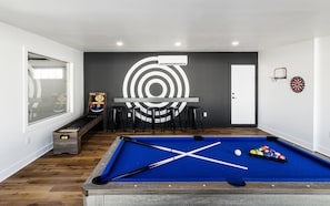 Game room offering ski ball, a dart board, Smart TV, and a pool table that can convert into a ping pong table or even a dining table.