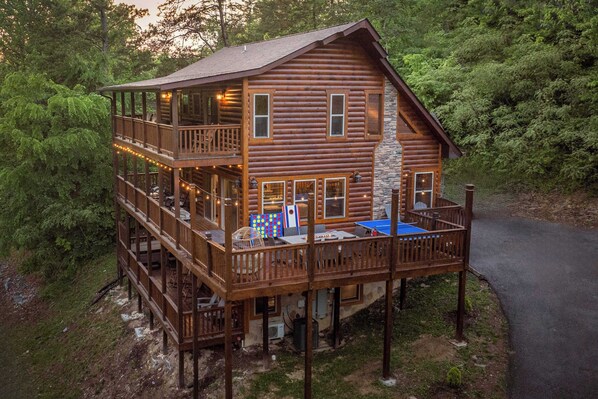 This stunning three-story cabin offers a classic log cabin feel with expansive wraparound decks, cozy lighting, and a peaceful wooded setting. Enjoy nature views, fresh mountain air, and the perfect retreat just minutes from Pigeon Forge attractions!
