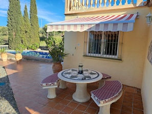 Covered shady,seating for 6 close to BBQ for outside dining. Roof terrace above.