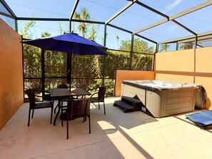 Covered lanai with seating area and hot tub