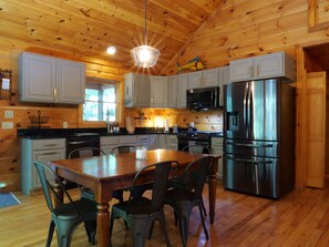 Fully equipped kitchen with modern appliances and dining area for meals.