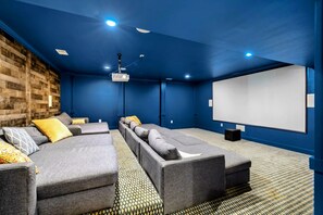 Enjoy movie nights in a cozy, state-of-the-art home theater with plush seating and a large projection screen