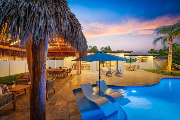 As the sun sets, the pool area glows, creating the perfect atmosphere for a night of backyard bliss.