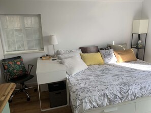 Comfy bed expands to queen size with quilts, pillows, and storage drawers.