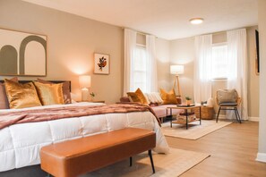 The downstairs master suite features a plush king-sized bed and cozy lounge area with twin-size sofa