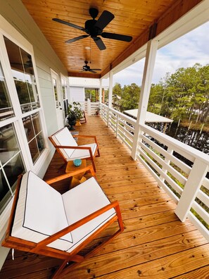 Charming balcony with comfortable seating and ceiling fans. 