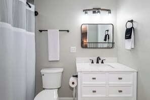 The primary bedroom boasts an ensuite bathroom, complete with a tub, sink, and toilet, providing convenience and privacy.
