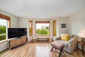 Main floor living room with fireplace, ocean view, Roku w/live TV, DVD player, books, games.