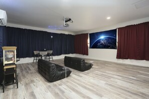 Movie theater with projector screen, leather seating, and a popcorn machine, perfect to enjoy and share good moments with family and friends.