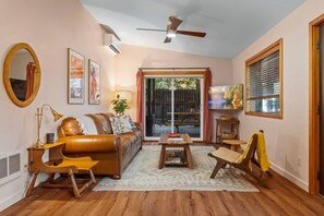 The living room area with large comfy couch, designer's chair & extra blankets to cozy up while watching Your favorite TV show.
