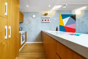 Sleek and modern kitchen featuring high-end appliances and stylish finishes. Perfect for cooking or enjoying a quick meal in a contemporary setting.