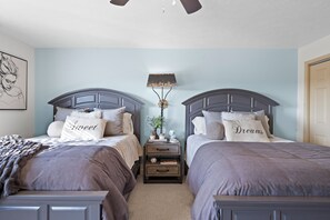 The master suite features a pair of queen beds, private ensuite, balcony access, & TV