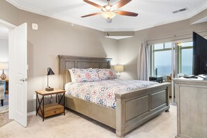 The primary king suite showcases a private ensuite, balcony access, & TV