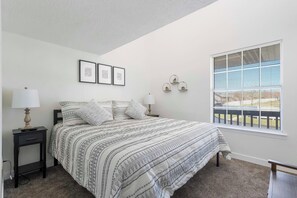 Bedroom 1 on the main floor with King bed, TV, and shared en-suite (main floor)