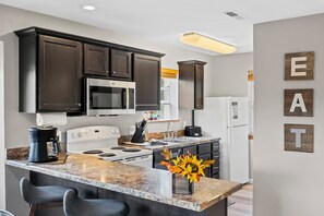 The cheerful kitchen offers ample space & all the comforts of home