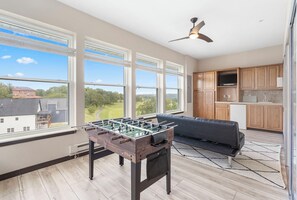 Bright sunroom with foosball, seating area, and TV