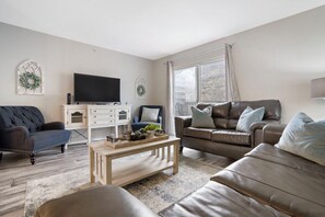 Open living space with TV, Full size sofa sleeper, and balcony access